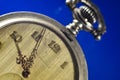 Antique pocket watch with vintage golden arrows on the old yellowed dial and clockwork key on a dark background. Time, history, te