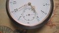 Antique pocket watch with white dial and gold moving second, minute and hour hands. Pocketwatch against background of an