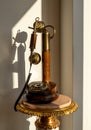 Antique polished wood candlestick telephone on marble table