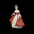 Antique porcelain figurine of a girl in a lush red dress. vintage ceramic girl figurine Royalty Free Stock Photo
