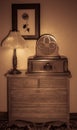 Antique radio, next to an antique lamp on top of an antique chest-of-drawers, a framed picture of a rose on the wall Royalty Free Stock Photo