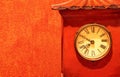 Antique red clock timepiece on a red wallpaper Royalty Free Stock Photo