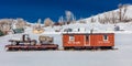 Antique red rarilroad car and old truck and wagon in middle of snowy field in central Colorado in Winter Royalty Free Stock Photo