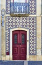 Antique red wooden door of a tiled house.