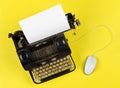 Antique retro mechanical typewriter with modern computer mouse on yellow background - digitalization, digitization or