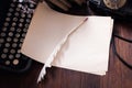 Antique retro rotary phone with vintage typewriter and a blank sheet of paper with feather pen on wooden board Royalty Free Stock Photo