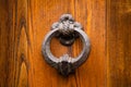 Antique round metal handle on a wooden front door. Beautiful brown color elegant entrance handle on the door. Vintage Royalty Free Stock Photo