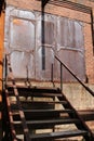 Antique rusted industrial doors at top of stairs