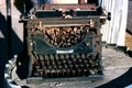 Antique rusted typewriter sitting on a wooden barrel Royalty Free Stock Photo