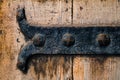 Antique rustic cast iron door hinge in a picturesque medieval ci Royalty Free Stock Photo