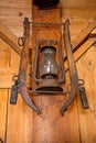 An antique rusty lanterns hang from a farmhouse wall