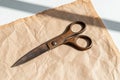 Antique rusty scissors on crumpled brown paper