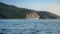 Antique sail ship with white sails and high mast sailing in the sea at sunset Royalty Free Stock Photo