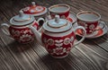 An antique set of ceramic teapots, cups, saucers on a wooden table. Royalty Free Stock Photo