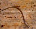 Antique sickle hand tool rusted on aged vintage wood Royalty Free Stock Photo