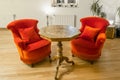 Antique side table with intarsia and red chair