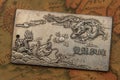 Antique silver plate with fighting dragons On Ancient oriental-style World Map Royalty Free Stock Photo