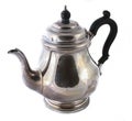 Antique silver teapot with a curved handle isolated on a white background.