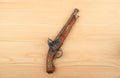 Antique single-shot muzzle-loading pistol with a percussion lock on a wooden background. Royalty Free Stock Photo