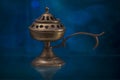 Antique Spanish brass bronze hand burner censer blue background and reflections Royalty Free Stock Photo