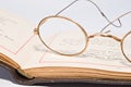 Antique spectacles on old open book