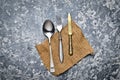 Antique spoon, fork, knife on a napkin lie on a gray concrete table. Top view Royalty Free Stock Photo