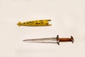 An antique steel dagger in a gold sheath with a beautiful pattern isolated on a white background. Cold weapons