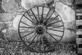 Antique steel wheel and wood pallet leaning against a stone wall