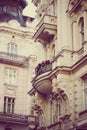 Antique stone buildings with baroque balcony and flowers with vintage treatment
