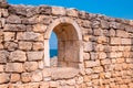 Stone wall with arched opening and sea view Royalty Free Stock Photo
