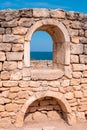 Stone wall with arched opening and sea view Royalty Free Stock Photo