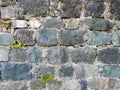 Antique stone wall. Background from a gray stone. The architecture of antiquity. Bricks of the Middle Ages. Remains of the castle