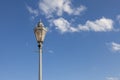 Antique street lamp with openwork ornament against the sky