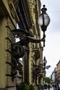 Antique street lamp in the shape of a devil. Perspective view of the street