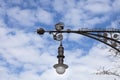 Antique street lamp in wrought iron. Sky and clouds