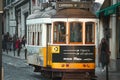 Antique street tram traveling along its tracks in a cityscape, Lisbon, Portugal