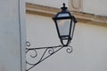 Antique style lamppost lantern attached to wall of building. Light off