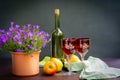 Antique stylized still life with a bouquet of roses, a bottle of wine and apples.