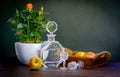 Antique stylized still life with a bouquet of roses, a decanter of alcohol and apples.