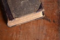 Antique tattered leather bound book laying on an old rustic wood