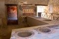 Antique tavern interior with fresco in Pompeii, Italy. Pompei ruins after volcano Vesuvius eruption. Historical heritage concept. Royalty Free Stock Photo