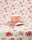 Antique tea cup full of tea on floral background Royalty Free Stock Photo