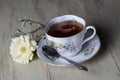 Antique Tea Cup Full of Tea with Yellow Daisy Flower Royalty Free Stock Photo