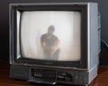 Antique television set with a silhouette of a person with a detailed face projected on the screen