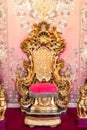 Antique throne in gold and red velvet. Old royal chair, luxury vintage