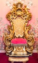 Antique throne in gold and red velvet. Old royal chair, luxury vintage