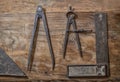 antique tools of carpenter on a wood, antique compass to trace and a square for wood edging Royalty Free Stock Photo