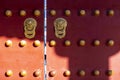 Antique traditional Chinese door style handle knocker with brass handles symbolic of lion head on red wood Door in Forbidden City Royalty Free Stock Photo