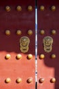 Antique traditional Chinese door style handle knocker with brass handles symbolic of lion head on red wood Door in Forbidden City Royalty Free Stock Photo