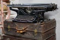 An antique typewriter stands on a vintage suitcase on a light background. Nostalgic still life, a set of correspondent Royalty Free Stock Photo